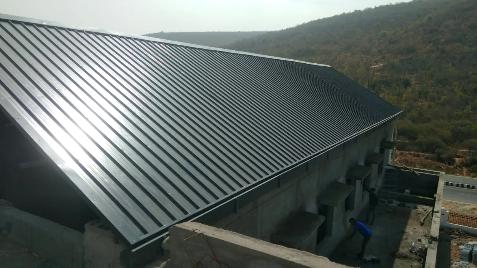 Completed industrial metal roofing over a large building.