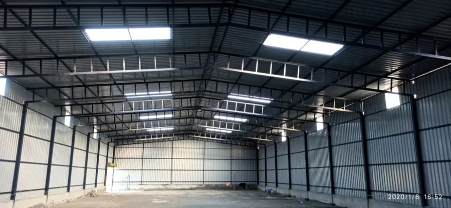 Completed industrial warehouse shed interior with steel trusses, roof sheets and daylight panels.