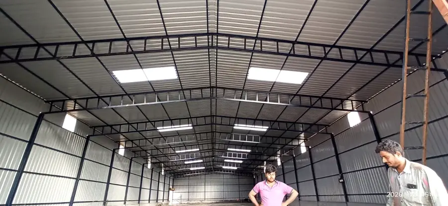 Industrial shed interior showing fabricated steel roof framing and metal cladding.